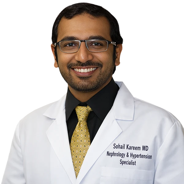 Portrait of Dr. Sohail Kareem wearing a white lab coat, black shirt and yellow pattern tie.